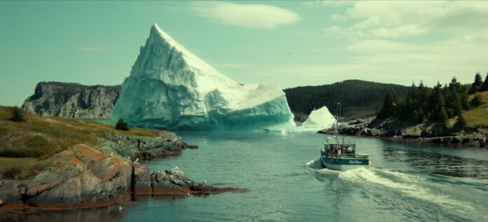 Below ending explained: a fishing boat heads towards the giant iceberg in Snook's Arm harbour